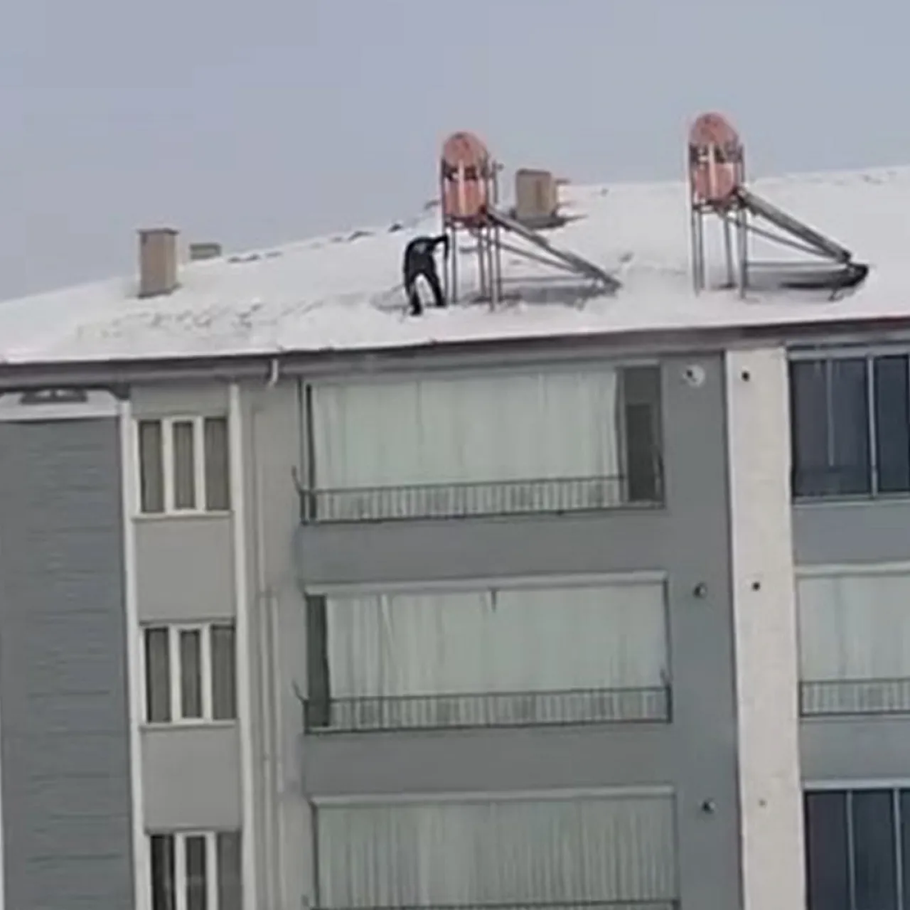 Elazığ'da çatıda tehlikeli kar mesaisi: Bir elinde kürek diğerinde Azrail