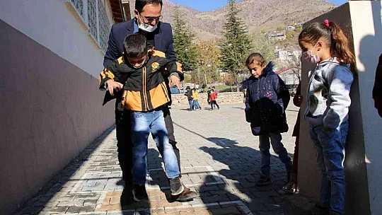 Engelli öğrencisini her teneffüs kucağında gezdiriyor