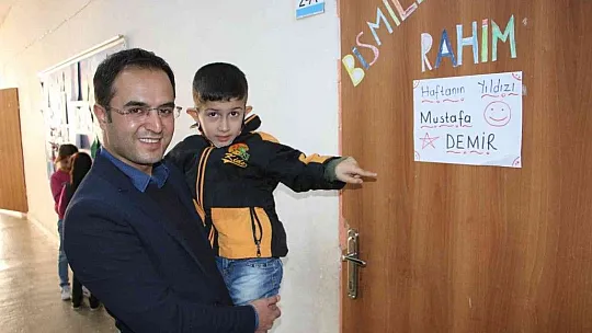 Engelli öğrencisini her teneffüs kucağında gezdiriyor