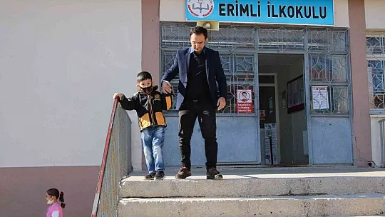 Engelli öğrencisini her teneffüs kucağında gezdiriyor