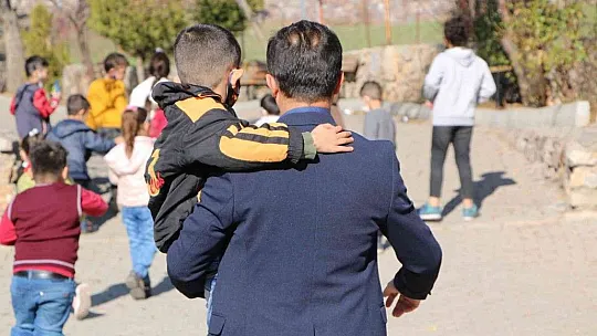 Engelli öğrencisini her teneffüs kucağında gezdiriyor